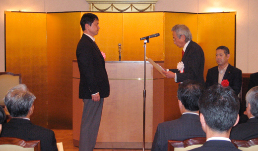 TTC会長の羽鳥光俊氏(右)から表彰状を授与される瀬戸康一郎氏(左)